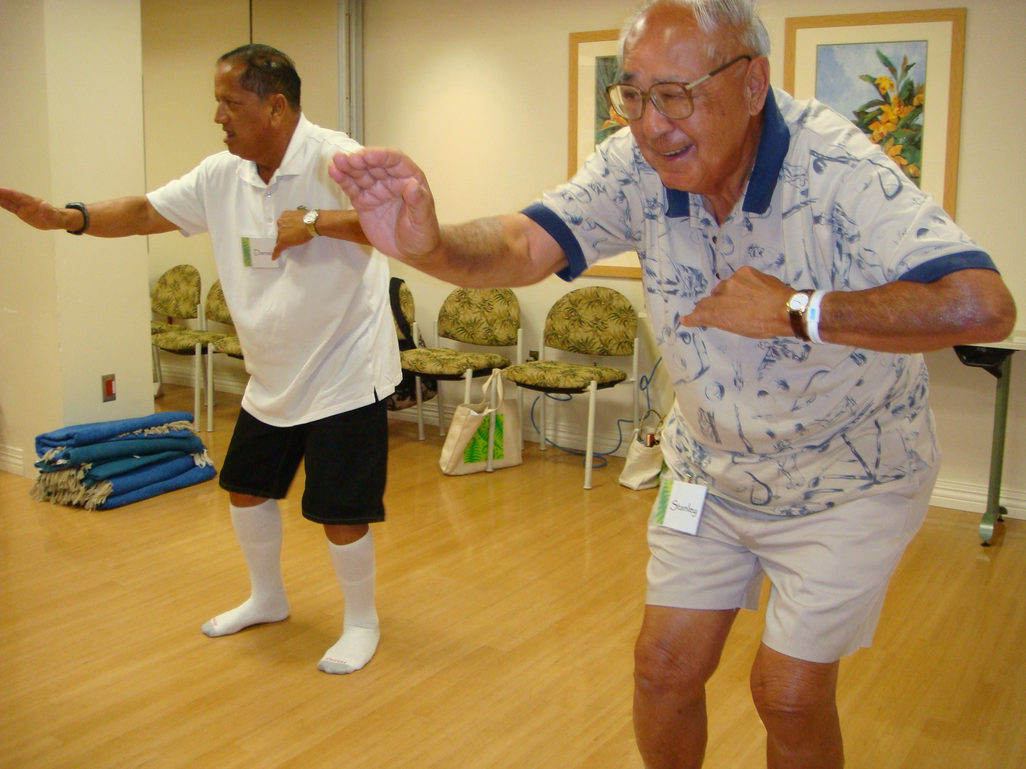 Older man with glasses dancing hula